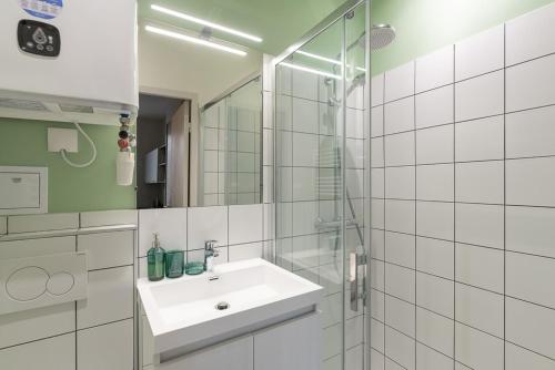 une salle de bain avec un lavabo et une douche en verre dans l'établissement Let's- 2 and 1 - Sweet Voltaire, à Lyon