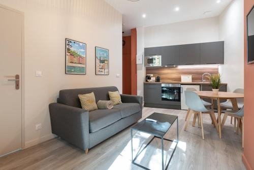 un salon avec un canapé et une table dans l'établissement Let's- 2 and 1 - Sweet Voltaire, à Lyon