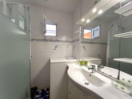 une salle de bain blanche avec un lavabo et un miroir dans l'établissement Appartement 2 chambres avec terrasse et parking à La Baule, proche plage - FR-1-245-218, à La Baule-les-Pins