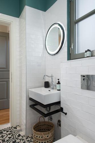 a white bathroom with a sink and a mirror at Living Yard Acropolis in Athens