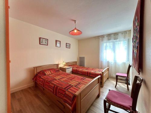 une chambre avec deux lits et une chaise et une fenêtre dans l'établissement Appartement 2 chambres avec terrasse et parking à La Baule, proche plage - FR-1-245-218, à La Baule-les-Pins