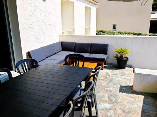 d'une table, de chaises et d'un canapé sur la terrasse. dans l'établissement Tanchet Beach House, à Les Sables-dʼOlonne