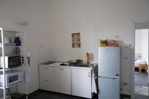 a kitchen with a white refrigerator and a sink at Attico San Mattia in Naples