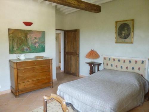 une chambre avec un lit et une commode en bois dans l'établissement Grande maison dans village médiéval, aux Arcs-sur-Argens