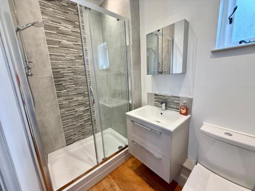 un baño con ducha y lavabo en The Manor Coach House, en Canterbury