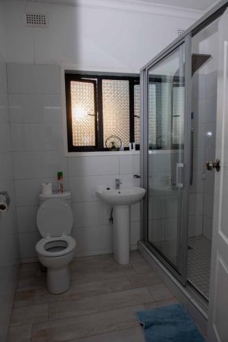a bathroom with a toilet and a sink and a shower at The Residence Apartments in Nyanda