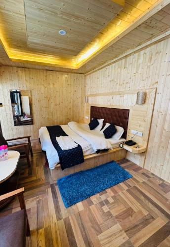 a bedroom with a large bed in a wooden wall at Himalayan Regency #nearmallroad #primelocation in Manāli
