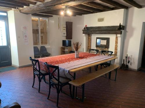 une salle à manger avec une table et des chaises et une cheminée dans l'établissement Gîte des Eperviers, à Étival