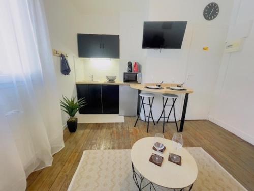 un salon avec deux tables et une cuisine dans l'établissement La Halte Urbaine - 2 guests - Wifi, au Mans