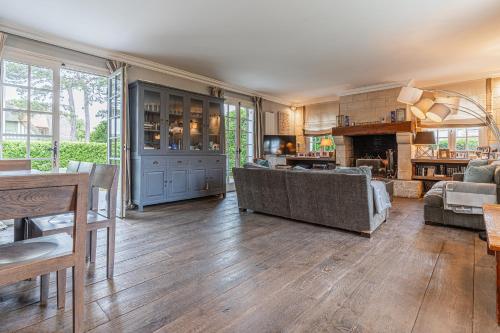 un salon avec un canapé et une cheminée dans l'établissement Luxueuse Chaumière 4 Chambres avec Piscine, à Deauville