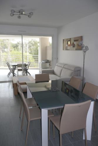 un salon avec une table, des chaises et un canapé dans l'établissement Very nice apartment 100 meters Calvi beach, à Calvi