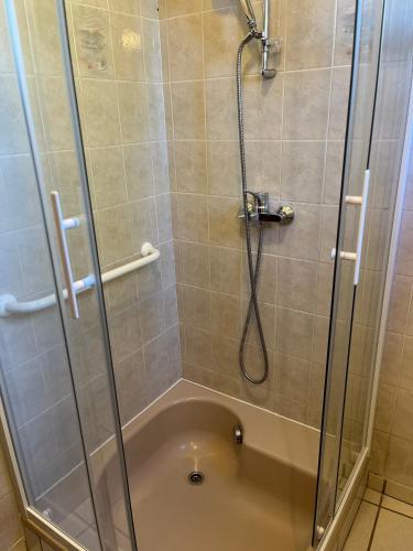 une douche avec une porte en verre et une baignoire dans l'établissement maison au coeur du village, à Ruoms