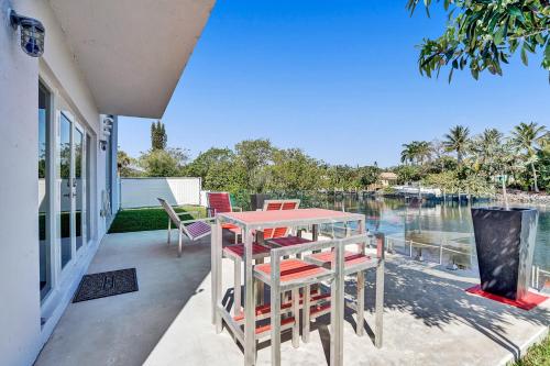 a table and chairs on a patio with a view of the water at Unique Retreat - Unit A: Cozy First-Floor Oasis in Deerfield Beach