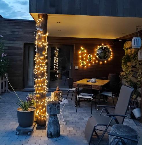 a patio with a table and string lights at La Chambre aux Pommes - Poupehan sur Semois in Bouillon