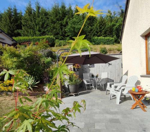 a patio with an umbrella and chairs and a table at La Chambre aux Pommes - Poupehan sur Semois in Bouillon