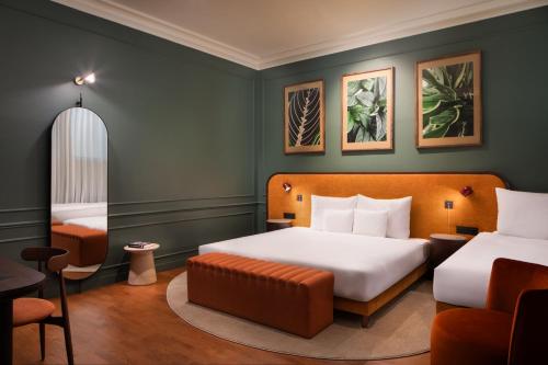 a hotel room with two beds and a chair at Verno House Budapest, Vignette Collection by IHG in Budapest