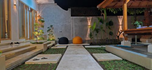 a courtyard with a building with stairs and plants at Peaceful 2BR House with Rice Field View Near Beach & Local Spots in Mendaya