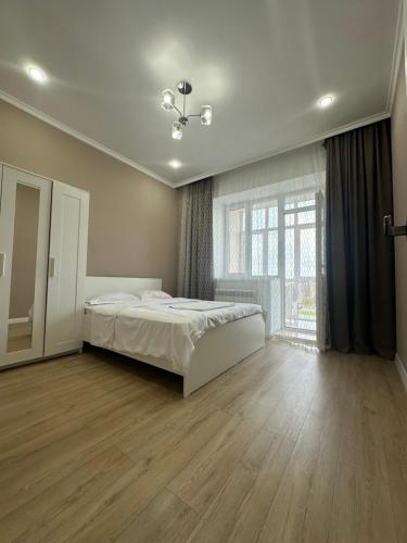 a bedroom with a bed and a large window at Park home Uralsk in Uralsk