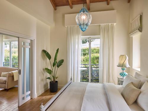 a bedroom with a large white bed and a window at Grecotel Eva Palace in Kommeno