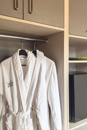 a white jacket hanging on a rack in a bathroom at Hotel Eden in Câmpulung Moldovenesc