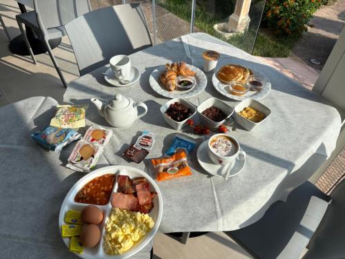 a table with plates of breakfast food on it at Abbaidda Hotel in Valledoria