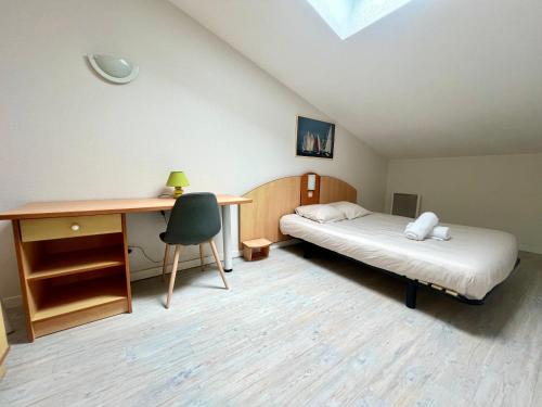 una habitación con una cama y un escritorio y un escritorio en Apartment with Balcony & Pool in La Rochelle, en La Rochelle