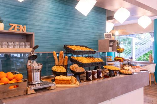 a bakery counter with various types of food on display at Kyriad Hotel Lyon Givors in Givors