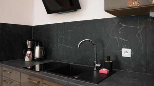 a kitchen with a sink and a counter top at VacationClub - Baltic Park Plaża 32 Apartment 2.2.4. in Świnoujście