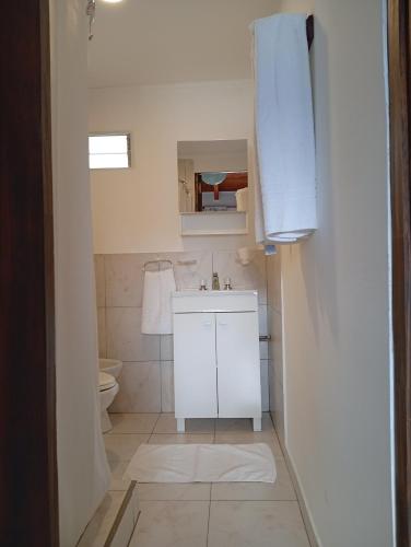 a white bathroom with a sink and a toilet at La Fortaleza Deptos in Villa Traful