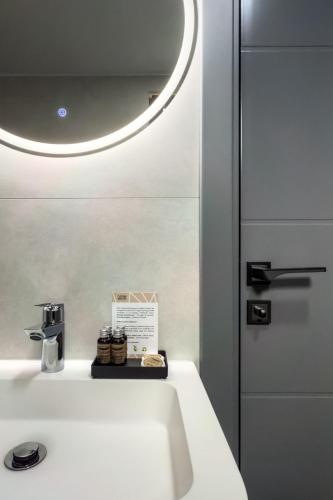 a bathroom with a white sink and a mirror at Hotel Eden in Câmpulung Moldovenesc