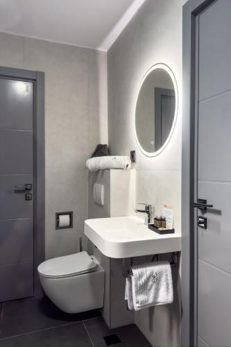 a bathroom with a sink and a toilet and a mirror at Hotel Eden in Câmpulung Moldovenesc