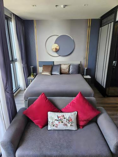 a bedroom with two beds and a couch with pillows at High Floor Beachfront 1 BR Condo with Scenic View in Pattaya South