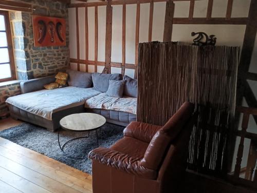 a living room with a couch and a chair at Maison de campagne aux notes africaines in Doische