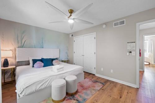 a bedroom with a white bed and a ceiling fan at 4 apartments 10 bedrooms - 2 and a half Miles from Ark in Williamstown