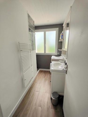 une petite salle de bain avec un lavabo et une fenêtre dans l'établissement Villa des Hauts Pins, à Ondres