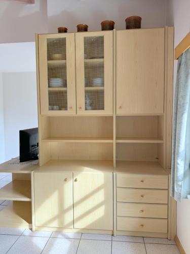 a wooden cabinet with glass doors in a room at Casa El Tobià in Pozza di Fassa