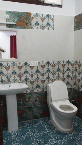 un baño con inodoro y lavabo en Manimahesh Home Stay, en Banikhet