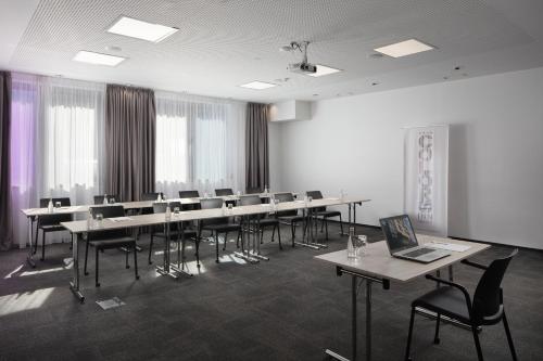 a conference room with tables and chairs and a laptop at Hotel Colors Inn in Sarajevo