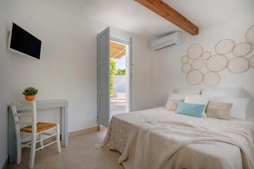 Un dormitorio con una cama, un escritorio y un televisor. en Trulli in Contrada - Monopoli, en Monopoli