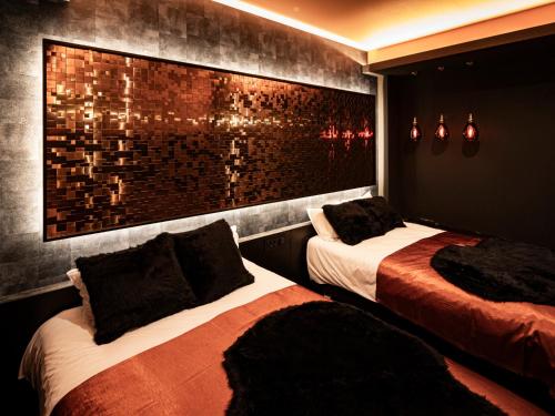 a bedroom with two beds and a brick wall at 十二ホテル -福岡空港- in Fukuoka