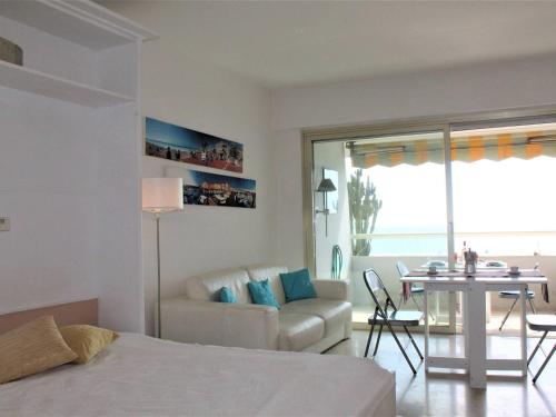 Cet appartement comprend une chambre avec un lit et un salon avec une table. dans l'établissement Studio cosy climatisé avec vue mer - 4 couchages, Villeneuve-Loubet Plage - FR-1-252A-17, à Villeneuve-Loubet