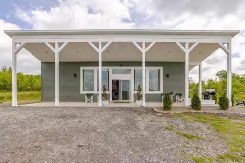 a small green house with a white roof at Altmar's Premier Luxury Cabin with 3000sf Mini Golf in Altmar