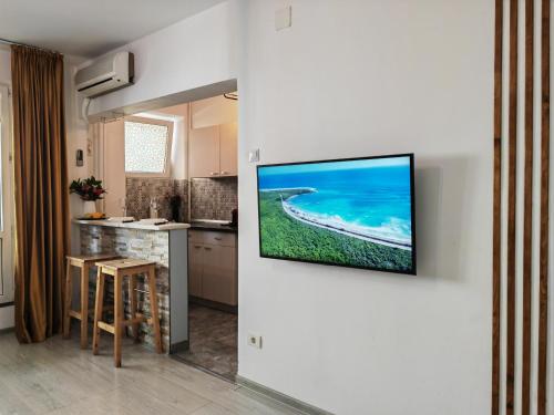 Una cocina con un televisor colgado en la pared. en Sunset Bucharest, en Bucarest