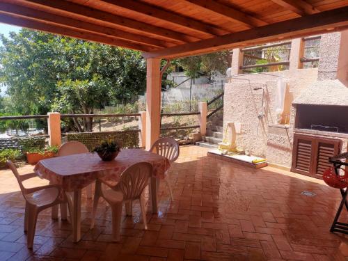 a patio with a table and chairs and a fireplace at Casa LeMa in Geremèas