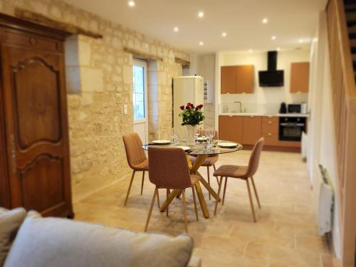 une cuisine et une salle à manger avec une table et des chaises dans l'établissement Domaine Les Chauveaux, 3 gites, 26 personnes, 1 salle, à Antran