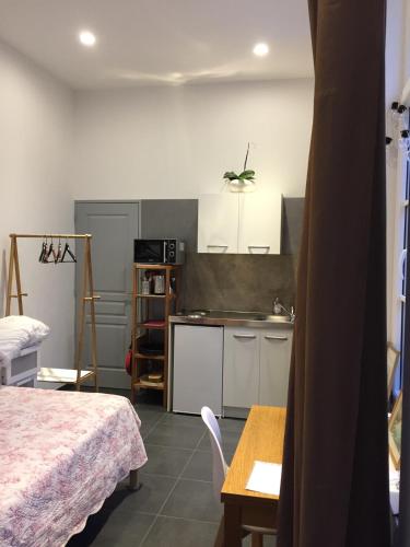 - une petite cuisine avec un lit et une table dans une chambre dans l'établissement Grand studio tout confort dans l'hyper centre, à Valenciennes