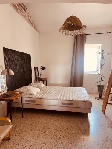 une chambre avec un grand lit et une fenêtre dans l'établissement L'Ostal des Embruscalles, à Claret