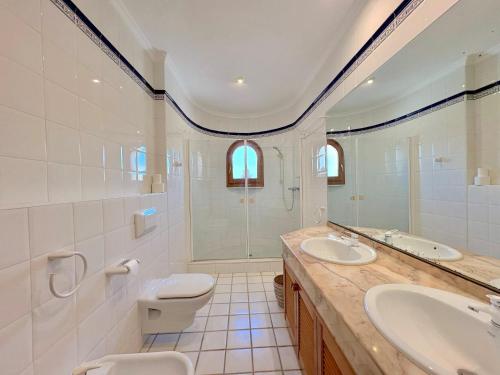 a bathroom with two sinks and a shower and a toilet at Villa Mar y Sol in Benitachell