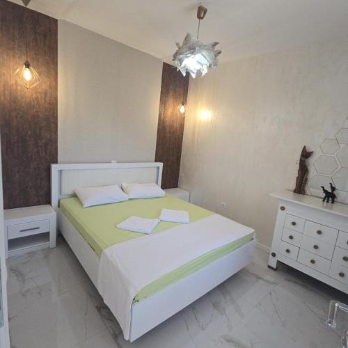 a bedroom with a white bed and a white dresser at Apartmani Sunce in Bar
