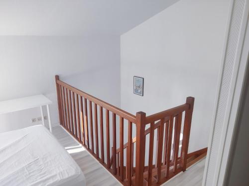 un escalier en bois avec un lit et un interrupteur dans l'établissement Charmant Duplex tout confort, à La Rochelle